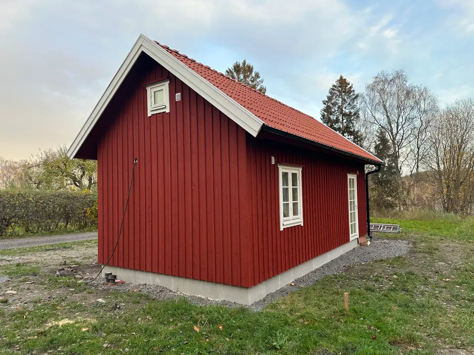 Faluröd stuga med tegeltak